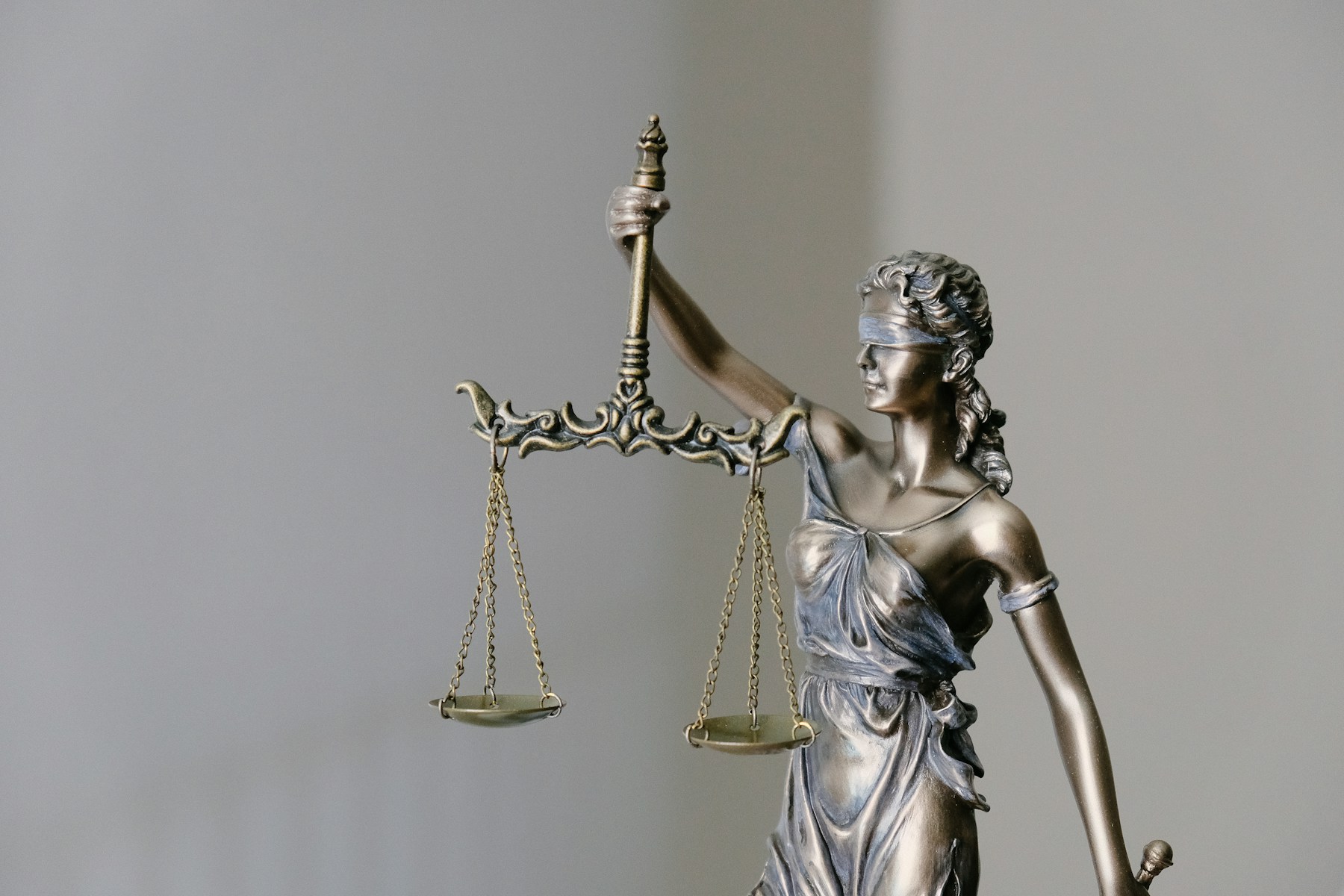 Lady Justice holding balanced scales in a professional legal setting